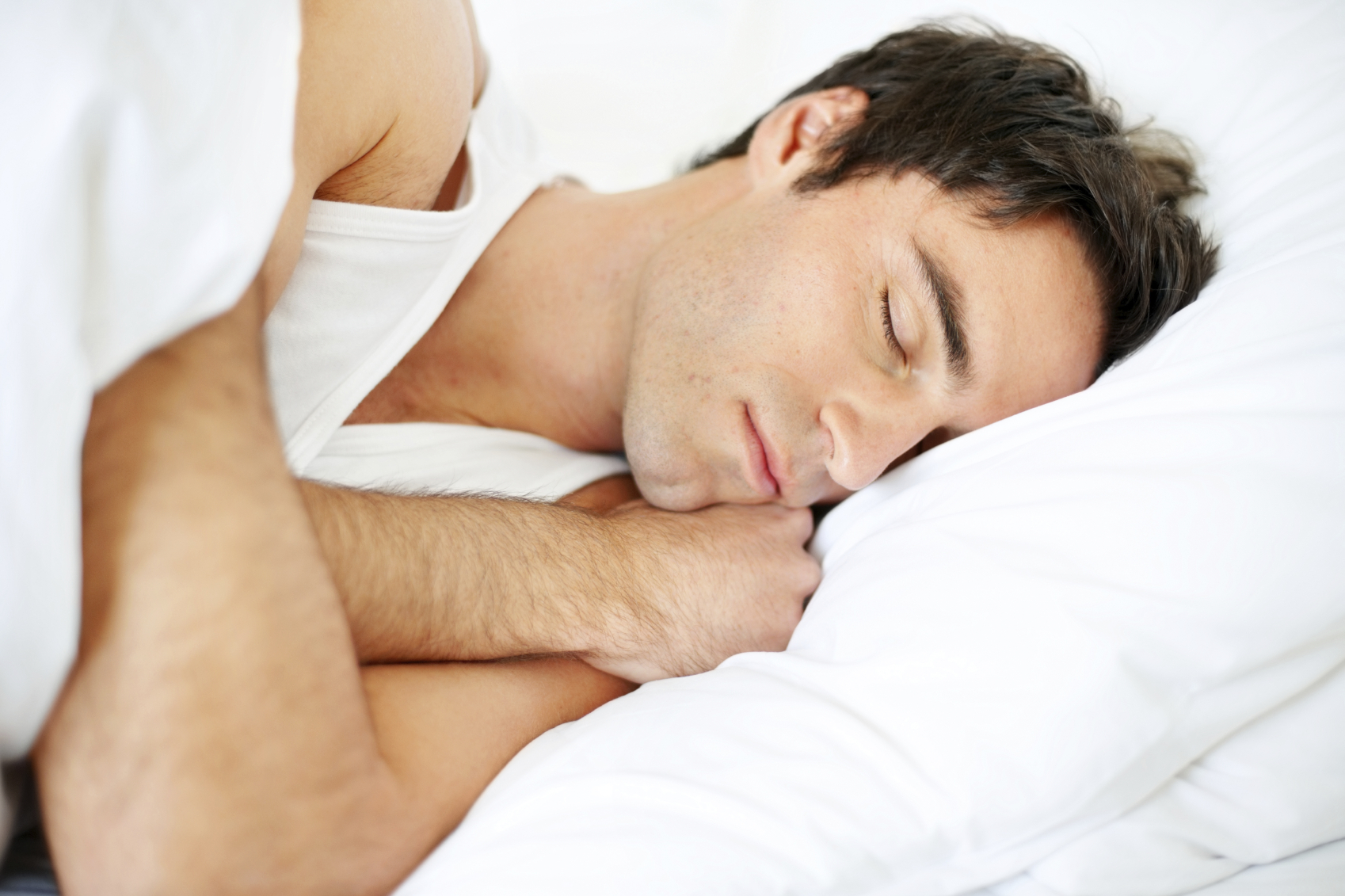 Closeup portrait of a young man sleeping on the bed